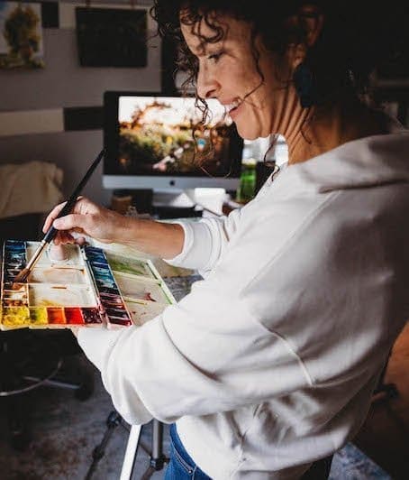 Jonalyn Fincher paints a watercolor of a garden in her studio